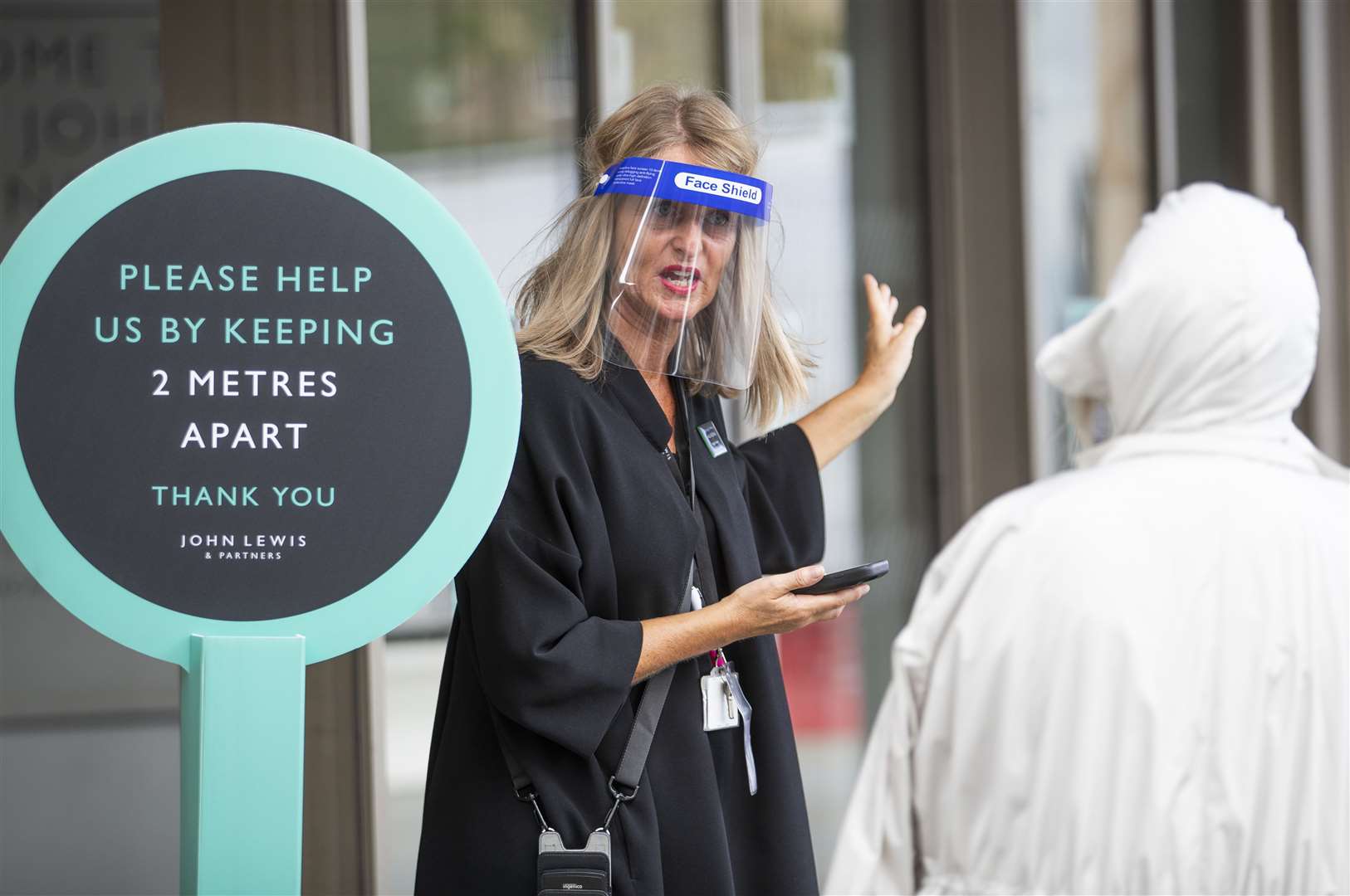 A member of staff directs shoppers at the John Lewis department store in Edinburgh, which reopened its doors on Monday (Jane Barlow/PA)