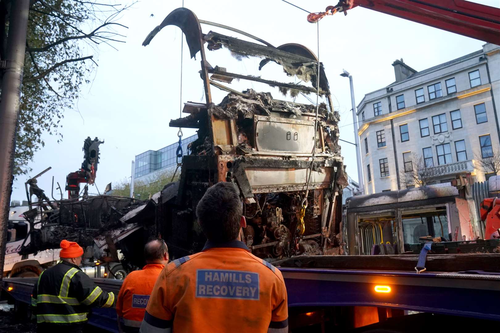 A burned out bus is removed from O’Connell Street in Dublin in the aftermath of violent scenes in the city centre on November 23 (Brian Lawless/PA)