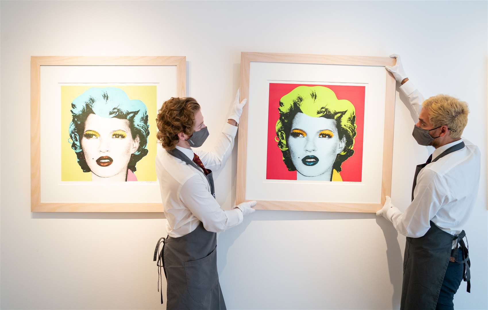 Christie’s art handlers adjust prints of Kate Moss by Banksy, which are also included in the sale (Dominic Lipinski/PA)