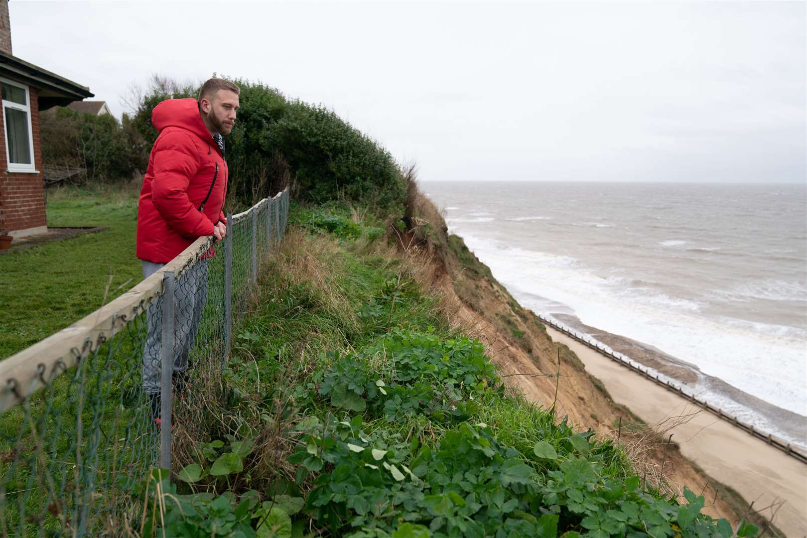 Antony Lloyd looks down to the beach from his garden after a cliff collapse at Mundesley in north Norfolk (Joe Giddens/PA)