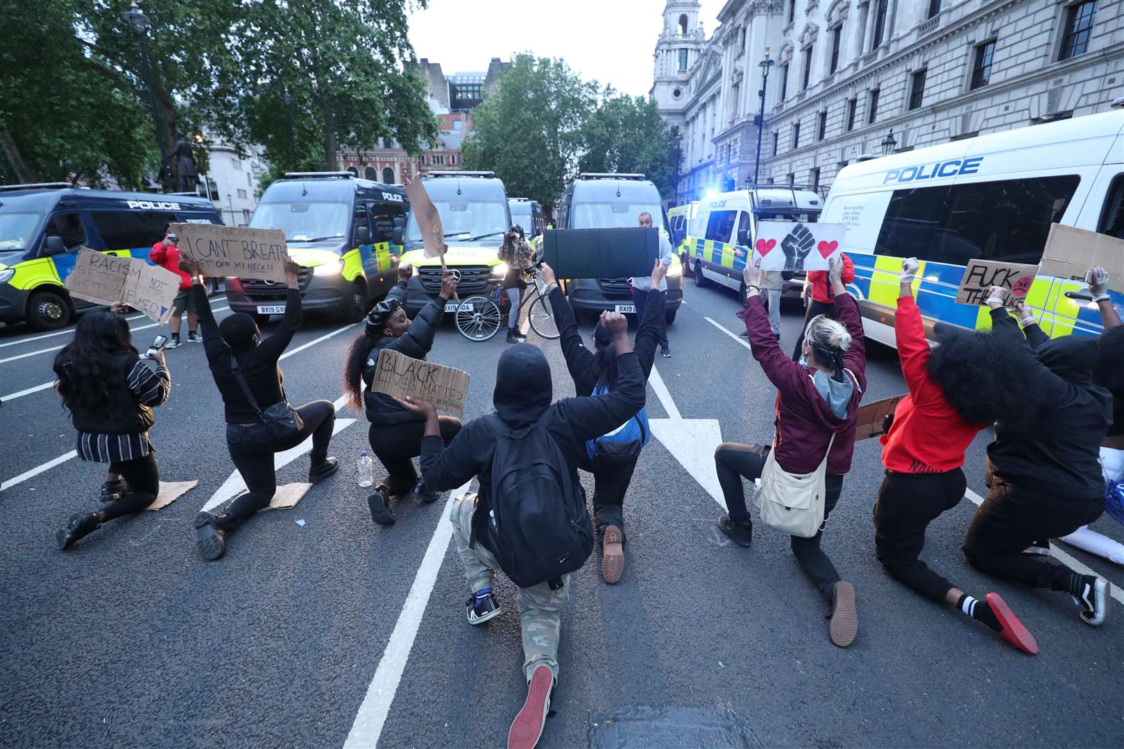 Protesters take a knee in front of police vans during a Black Lives Matter protest rally in Parliament Square (Yui Mok/PA)