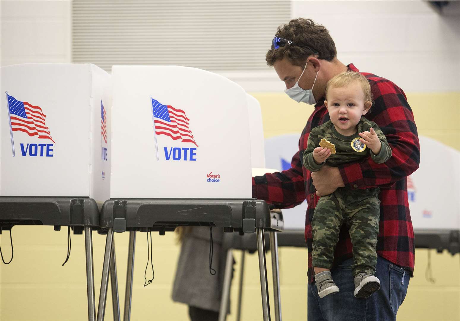 Tommy Tye celebrates his first birthday by accompanying his father Russell to vote at Alanton Elementary School in Virginia Beach, Virginia (Kaitlin McKeown/The Virginian-Pilot via AP)