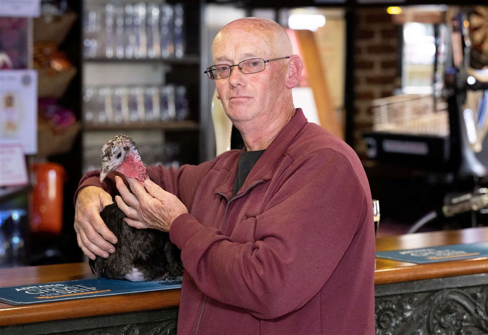 Dave Brooker in the pub and with his pet turkey T2. Picture: SWNS