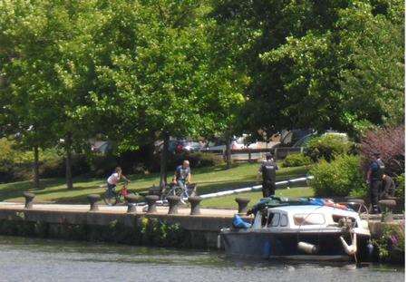 Police officers examine the fire-damaged houseboat