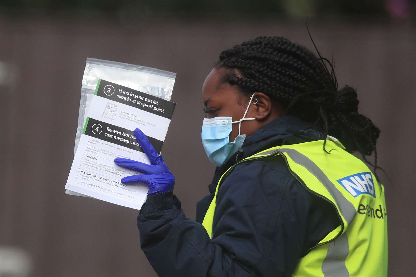 Staff hand out self-test kits at a coronavirus testing centre in Bolton (Danny Lawson/PA)