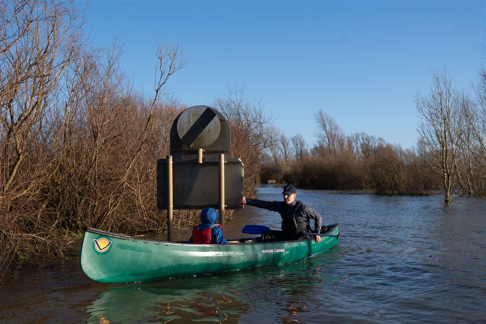 Anthony Gleave and his son Arthur, 3, canoe along the A1101 (Joe Giddens/PA)