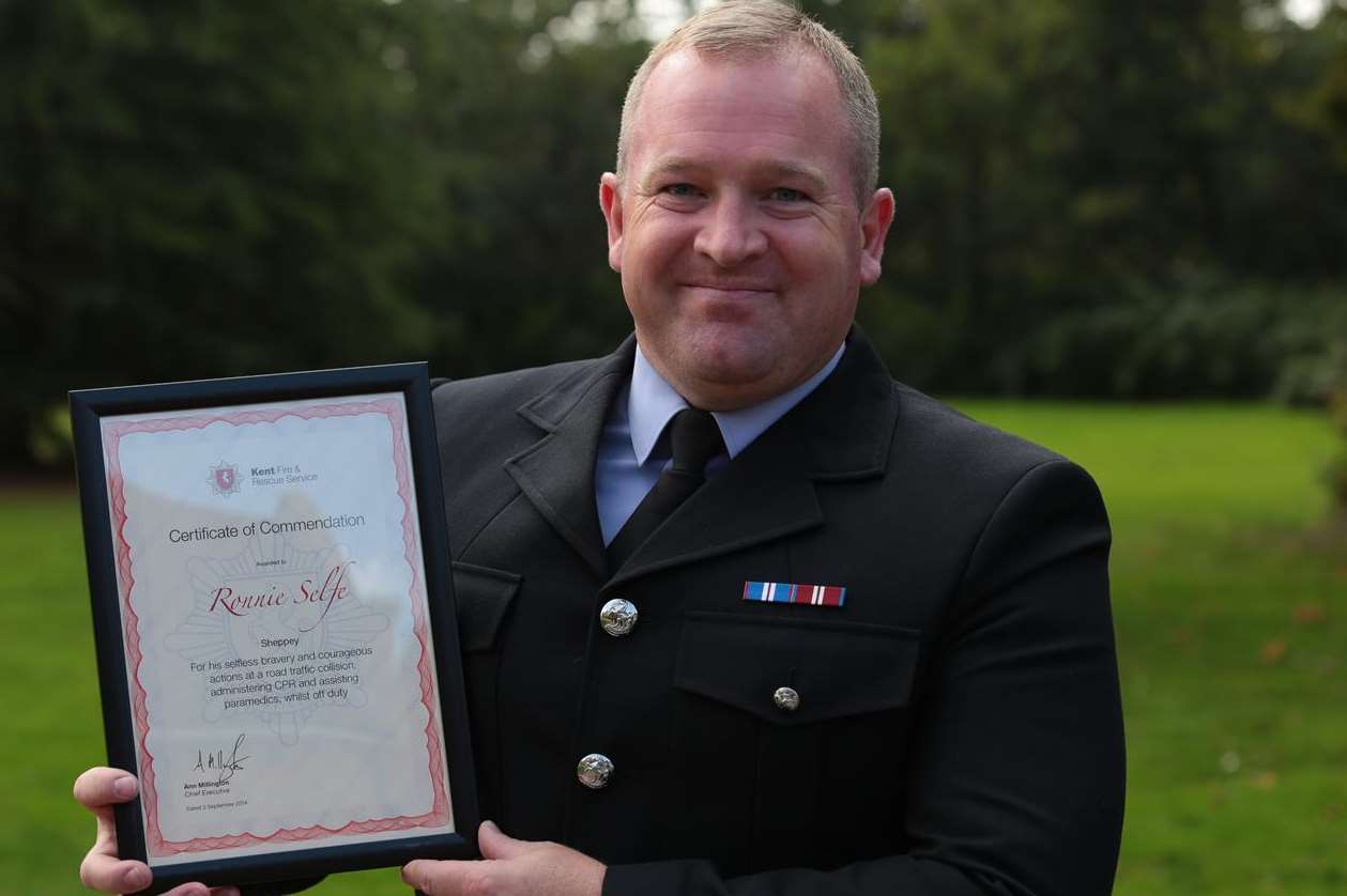 Firefighter Ronnie Selfe with his certificate of commendation