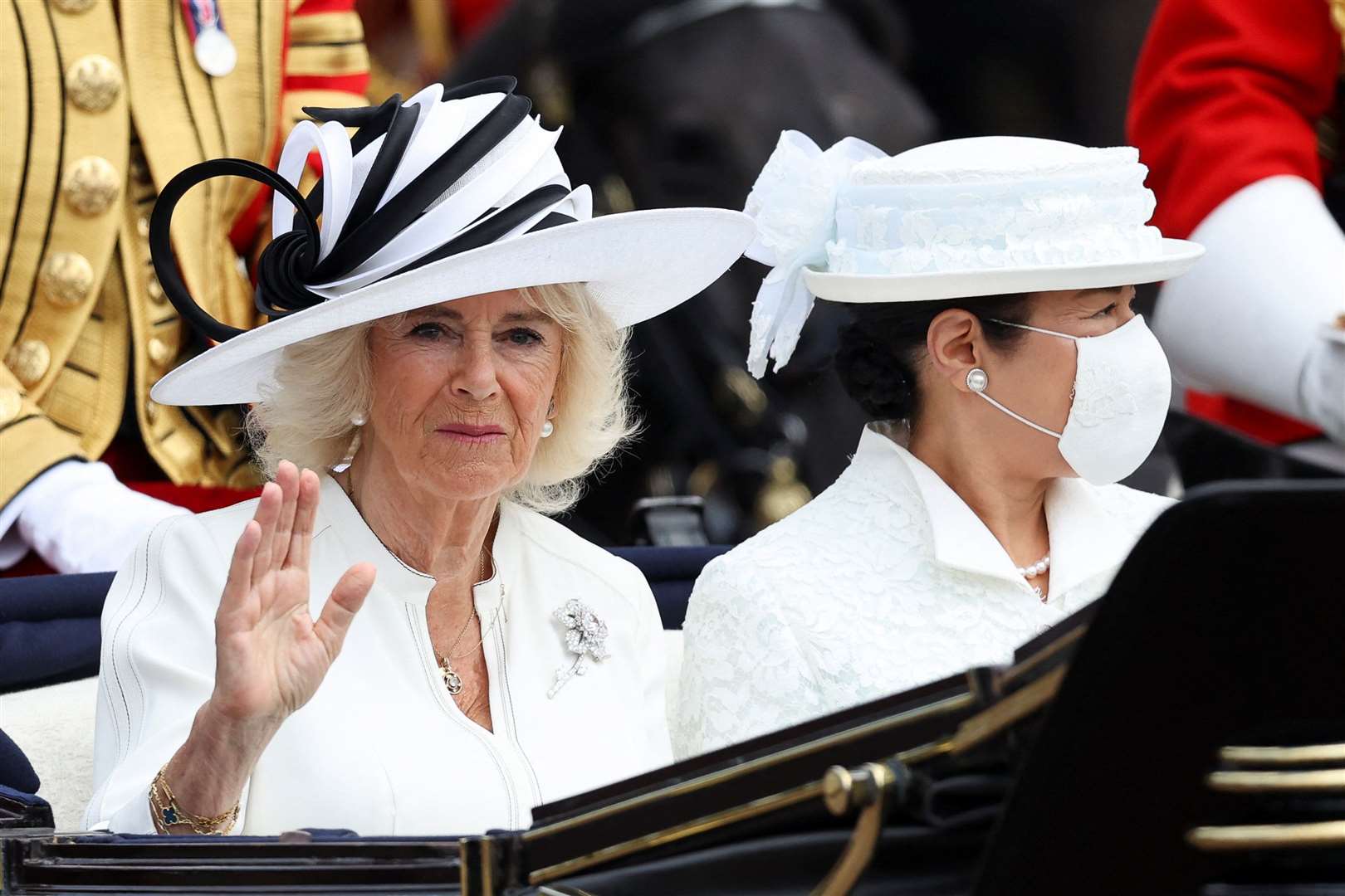 Camilla waves during the procession to the palace (Isabel Infantes/PA)