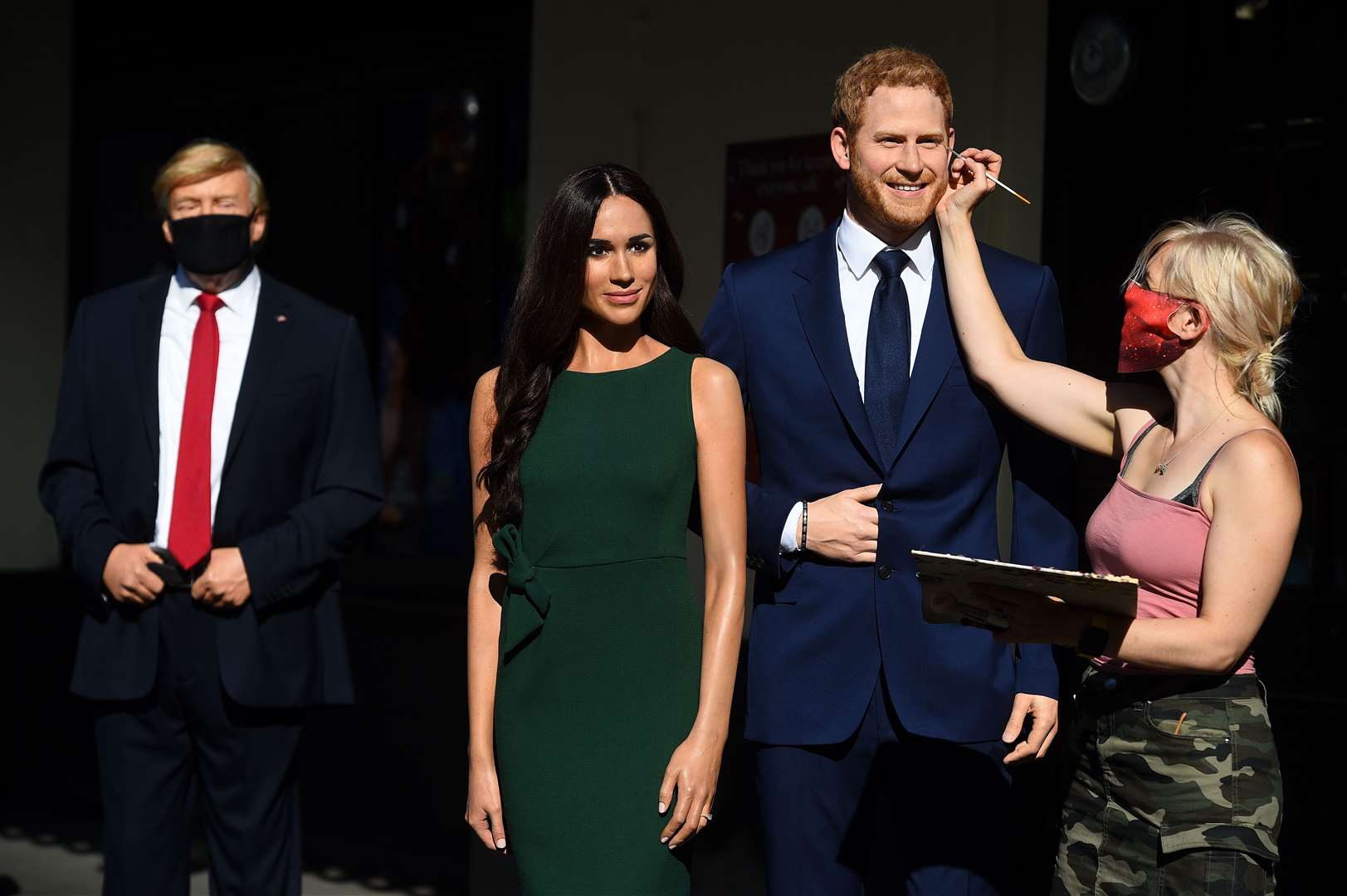 An artist puts the finishing touches to the wax figures of the Duke and Duchess of Sussex, in the entrance line at Madame Tussauds in London (Kirsty O’Connor/PA)