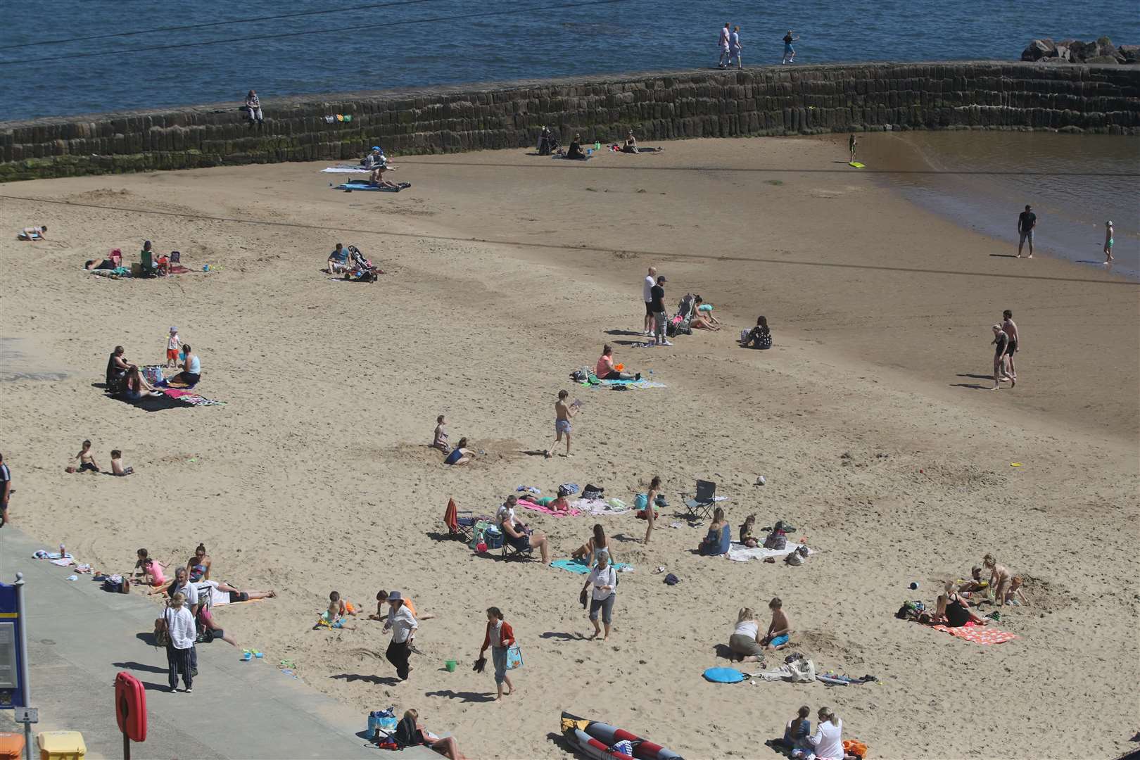 Members of the public enjoy the sun on Cullercoats Beach while trying to keep to social distancing guidelines (Owen Humphreys/PA)