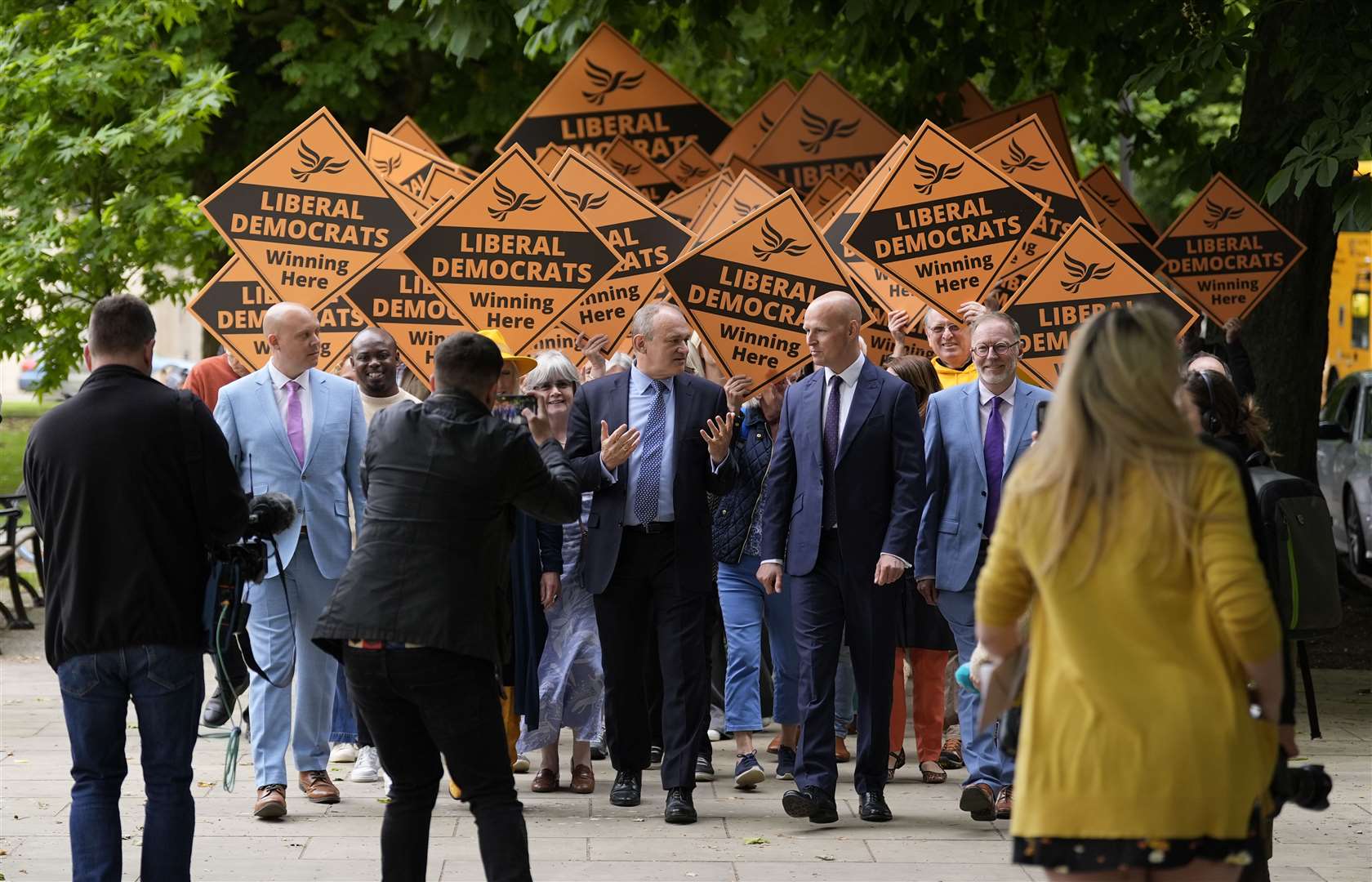 Liberal Democrat leader Sir Ed Davey (centre) chats with Liberal Democrat prospective parliamentary candidate for Cheltenham Max Wilkinson (centre right) during a visit to the town centre (Andrew Matthews/PA)