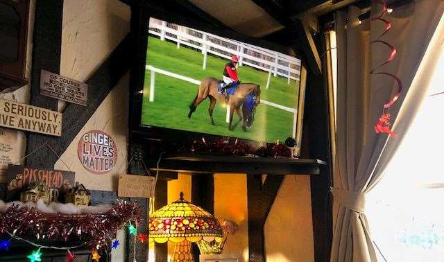 With family photos, a lamp and covers on the seat, this little corner of the pub, under the telly, was the warmest