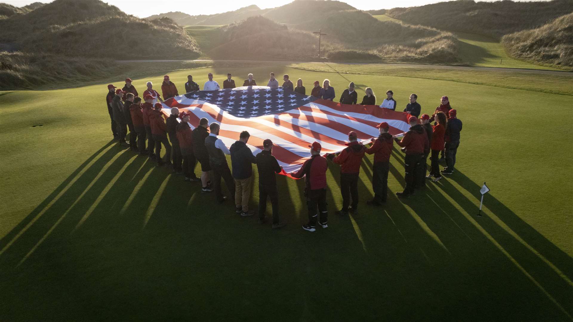 Trump International Scotland staff hold the American flag in celebration of Donald Trump’s election victory (Derek Ironside at Newsline Media/PA)