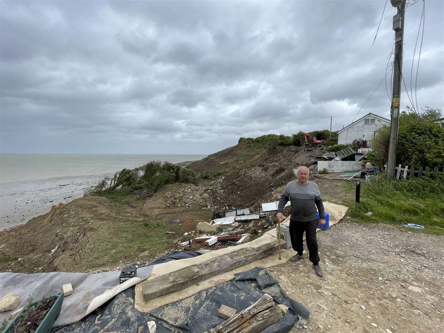 Malcolm Newell standing at the end of Surf Crescent one year after the huge cliff collapse