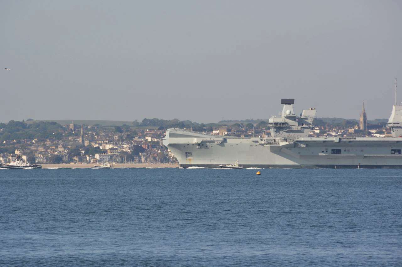 The Royal Navy aircraft carrier HMS Queen Elizabeth dwarfs Ryde on the Isle of Wight as it sails from anchor off Gosport, Hampshire, for sea trials on Friday, May 15 (Ben Mitchell/PA)