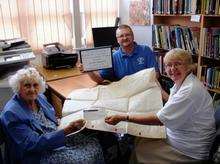 oyce Fuller, chairman of the Sittingbourne Society presents the John Jordan Bequest cheque to Alan Abbey, chairman of the Historical Research Group of Sittingbourne, watched by librarian Karen Paul