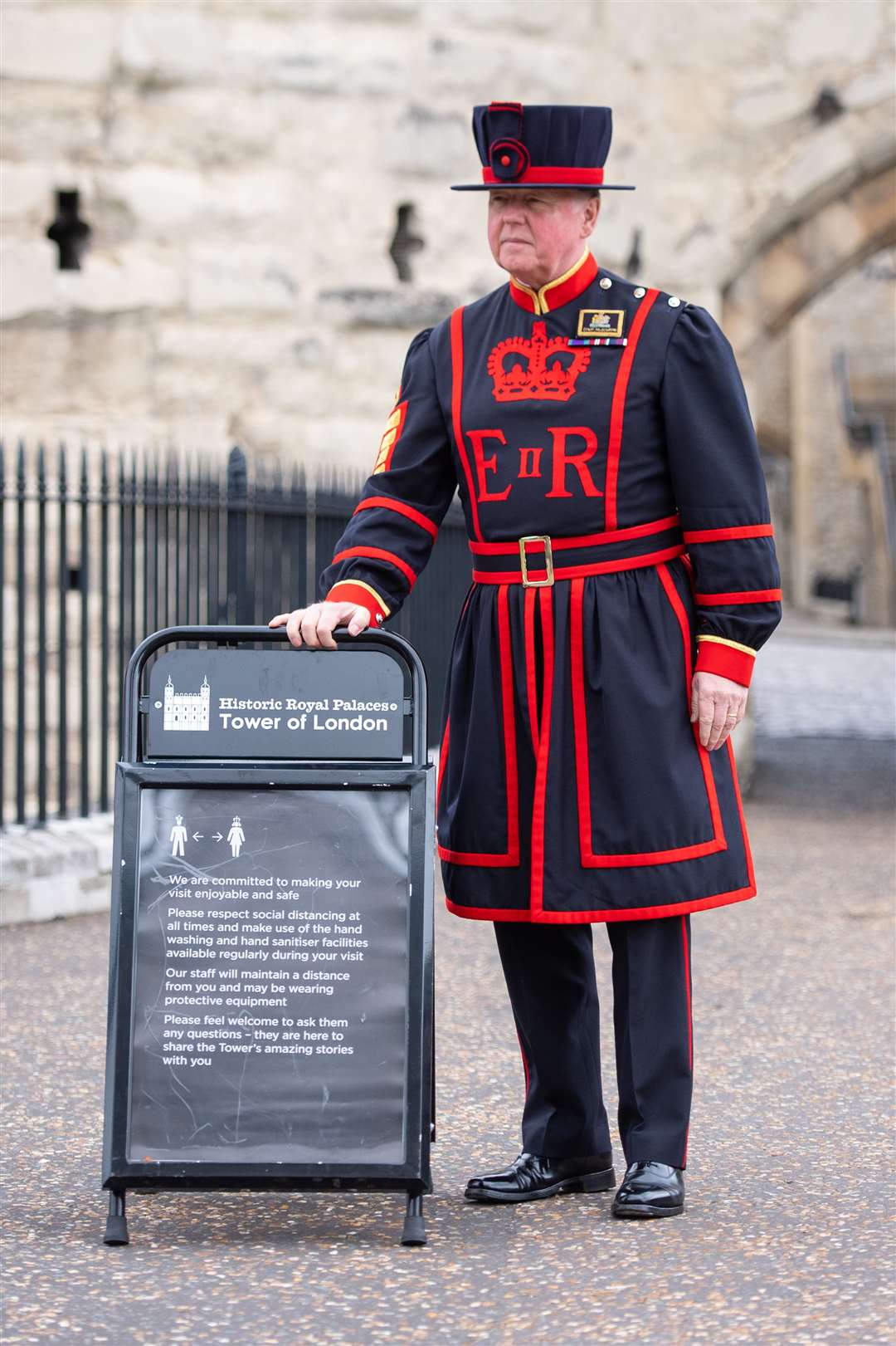 Chief Yeoman Warder Peter McGowran puts out social distancing signs for visitors to follow (Dominic Lipinski/PA)