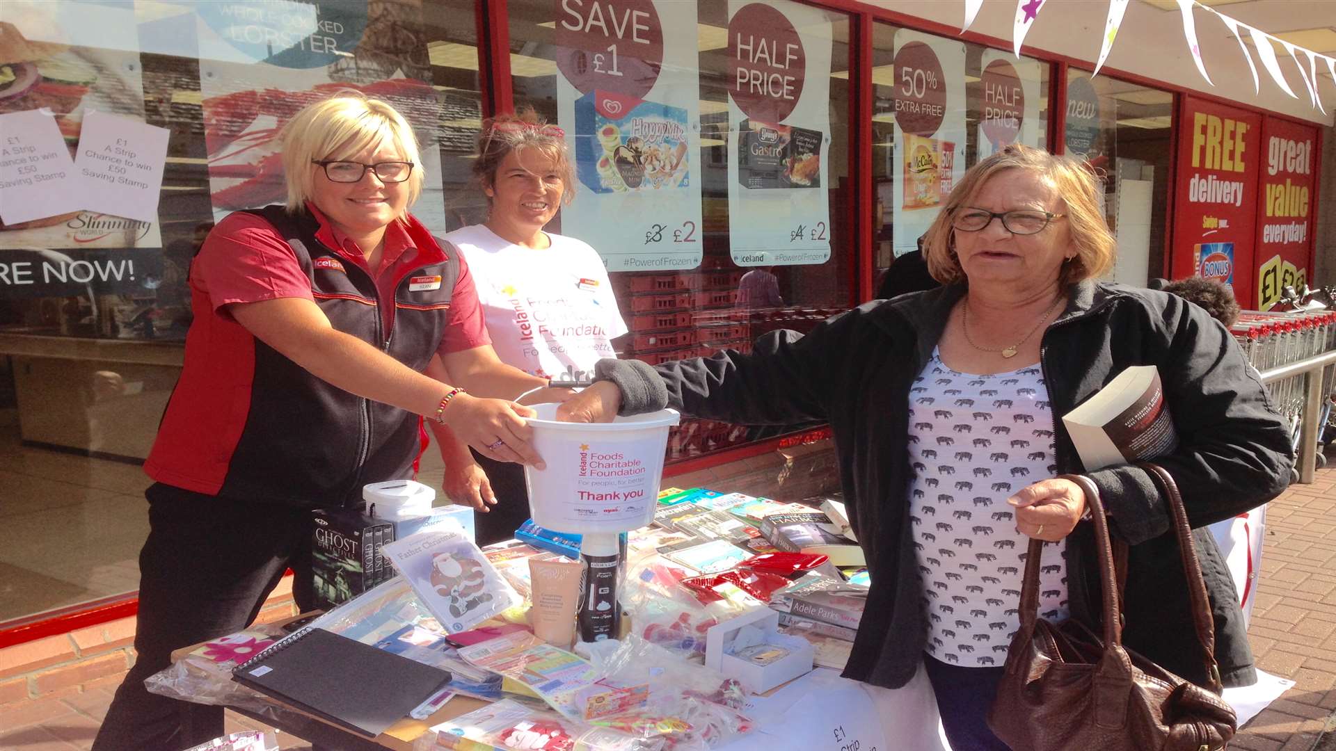 Sian Ferns and Paula Netherclift from Iceland, Deal, accept a donation from Linda Thorp