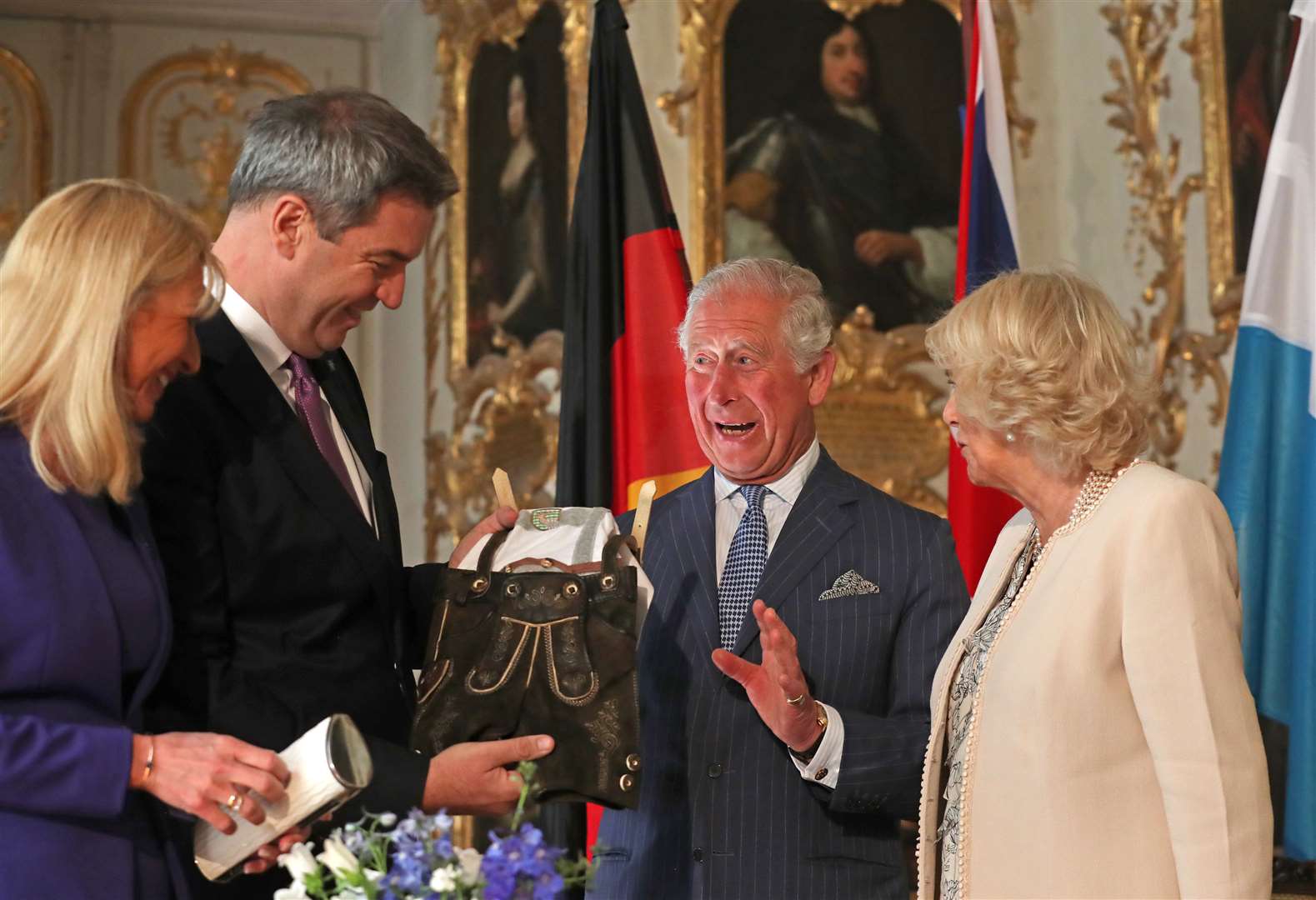 Chalres and Camilla receiving a pair of baby lederhosen for Archie from the Minister-President of Bavaria Markus Soder (Steve Parsons/PA)