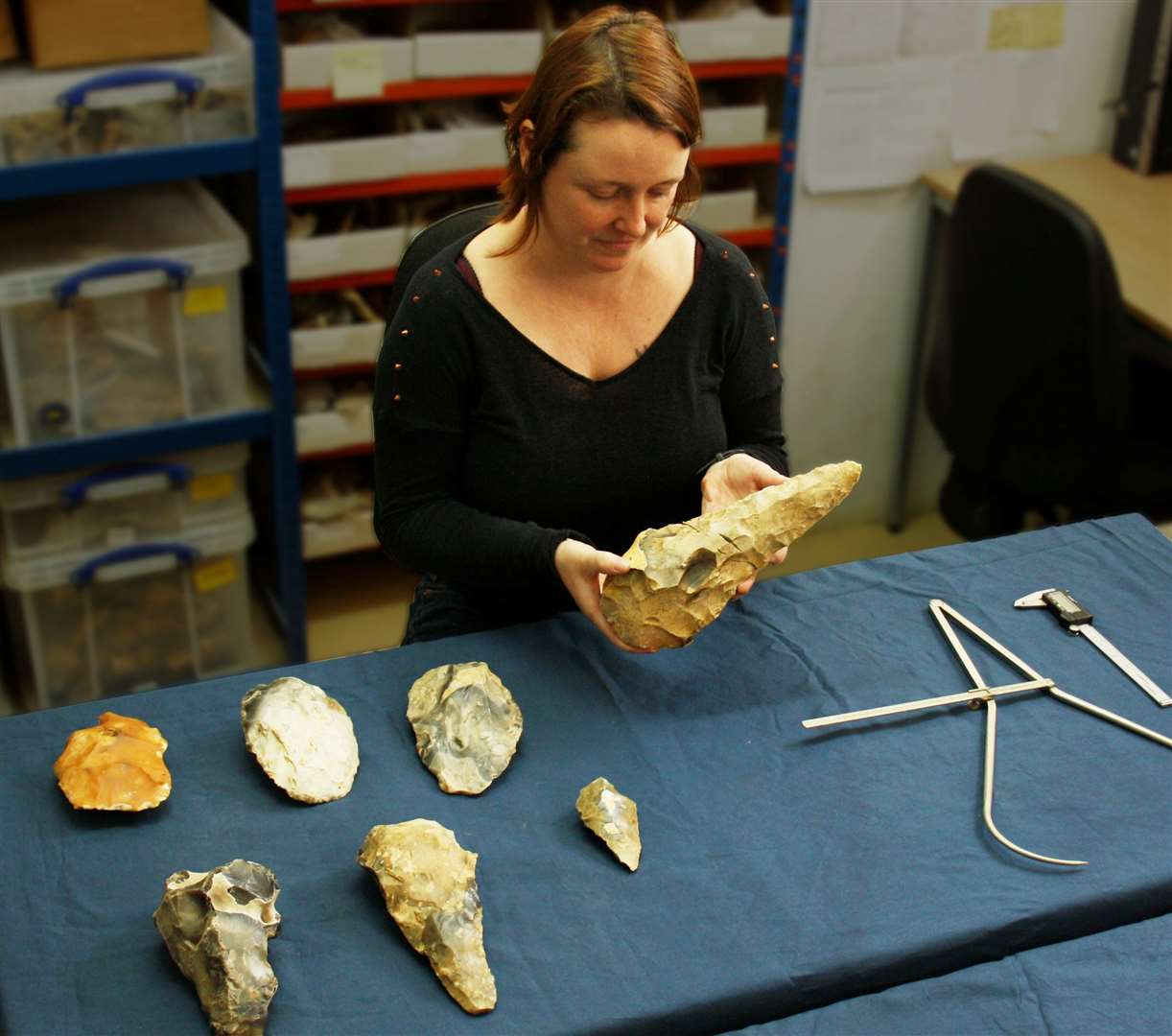 Senior archaeologist Letty Ingrey measures the largest giant handaxe found at the site in Frindsbury. Picture: Archaeology South-East/ UCL