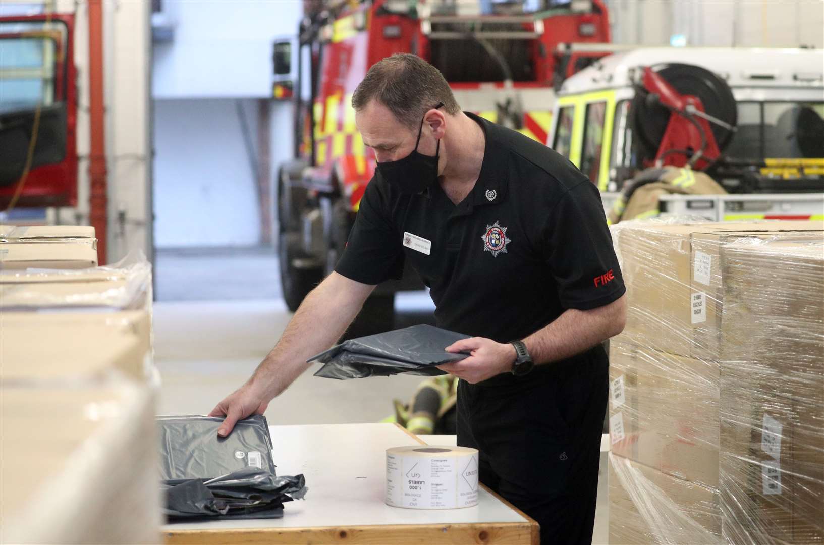 Surrey Fire and Rescue group commander David Nolan sorts through Covid-19 home testing kits at Woking Fire Station (Steve Parsons/PA)