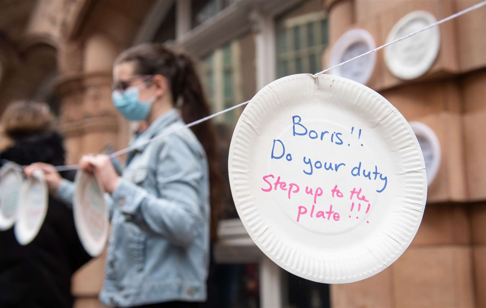 Demonstrators hung up paper plates carrying slogans calling for the Government to extend free school meals provision during a recent protest outside the Department for Education (Dominic Lipinski/PA)