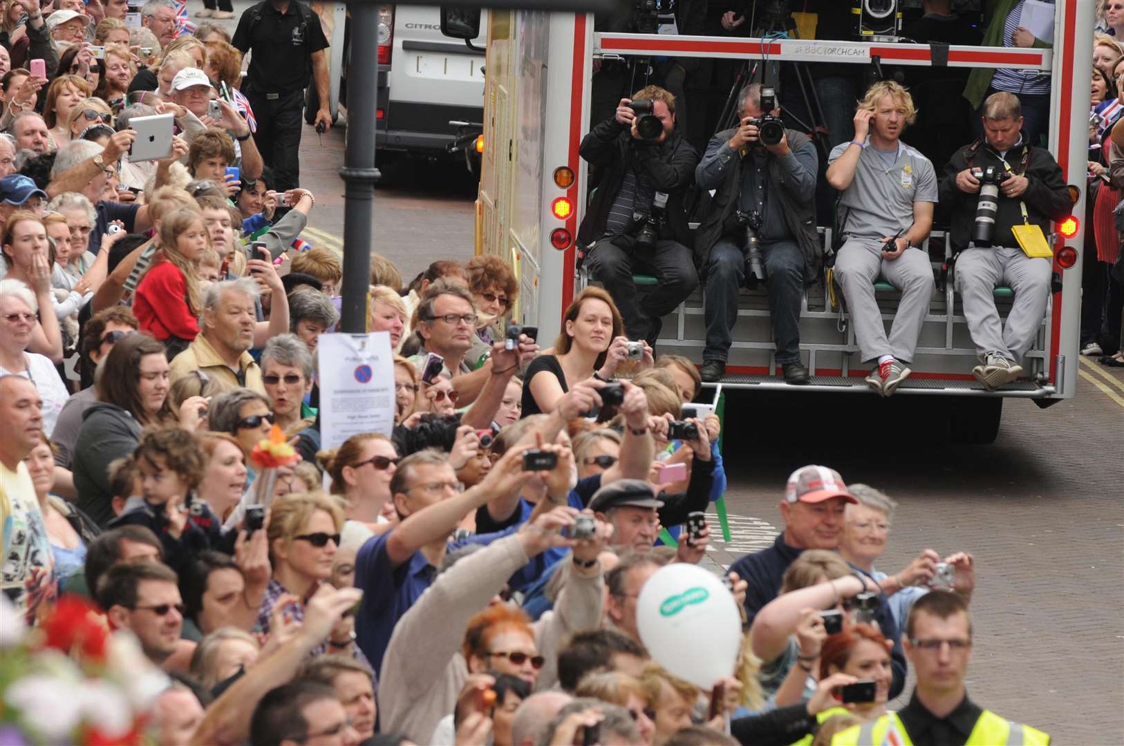 Photographers taking a ride ahead of the torchbearer in Ashford