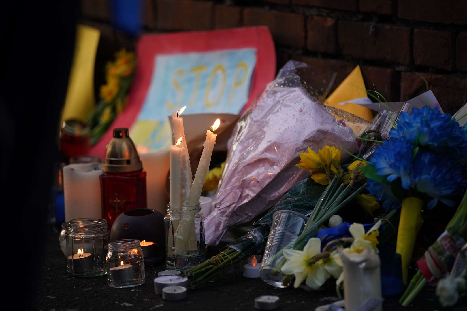 Flowers and candles at a vigil outside the Ukrainian embassy in Dublin over the Russian invasion of Ukraine (PA)