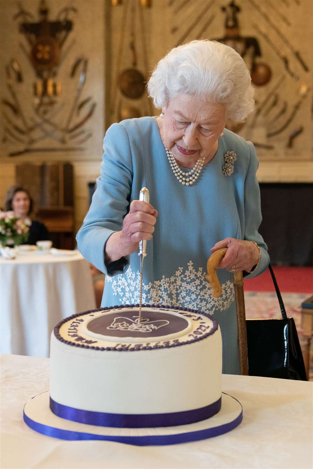 The Queen cuts a cake to celebrate the start of the Platinum Jubilee during a reception in the Ballroom of Sandringham House (Joe Giddens/PA)