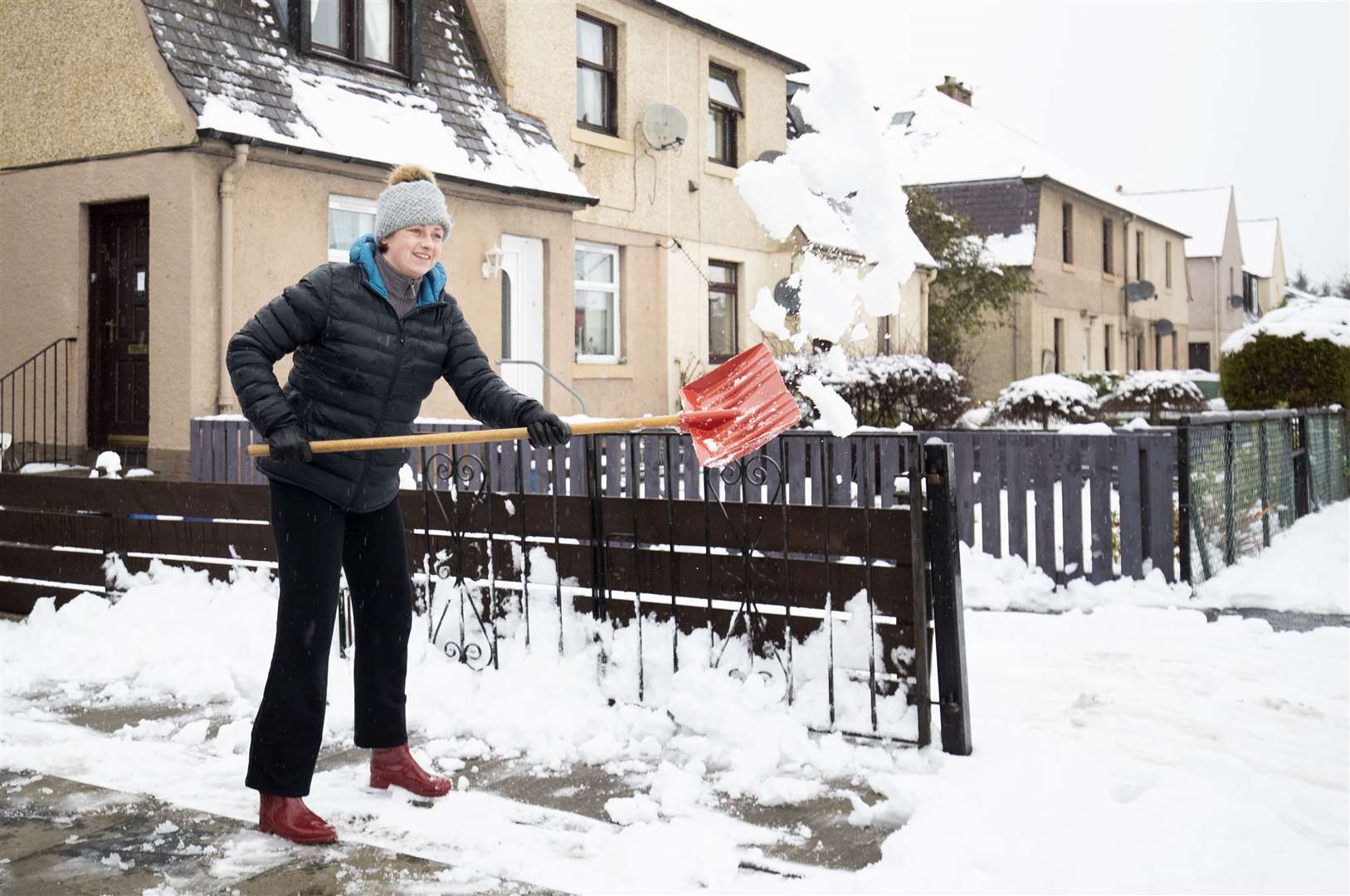 Kasia Wojcik clears snow from her driveway in Penicuik (Jane Barlow/PA)