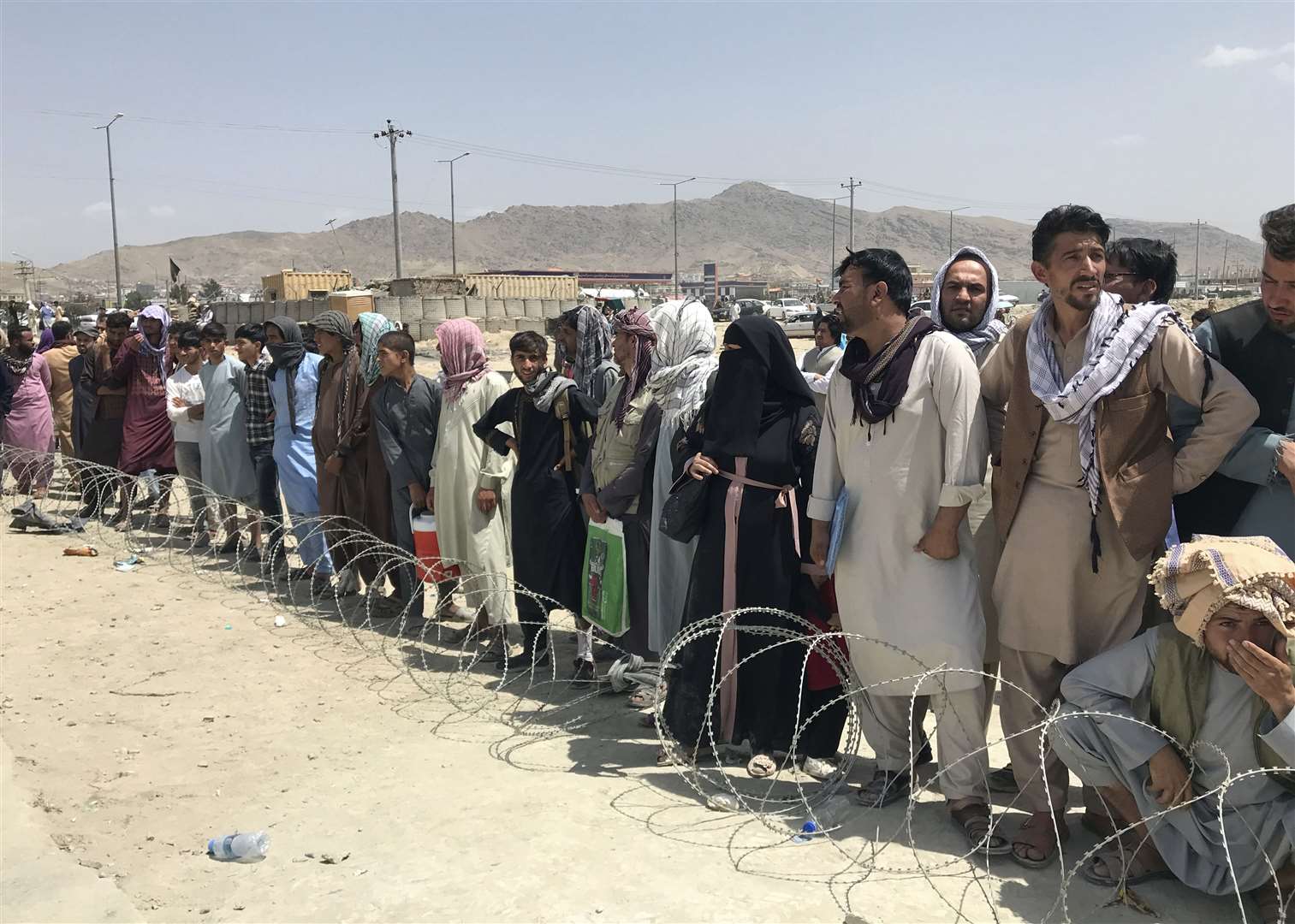 Hundreds of people gather outside the international airport in Kabul, Afghanistan (AP)