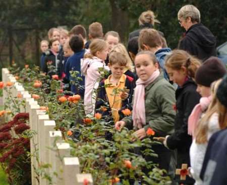 Children gather at the war graves in Aerodrome Road, Hawkinge