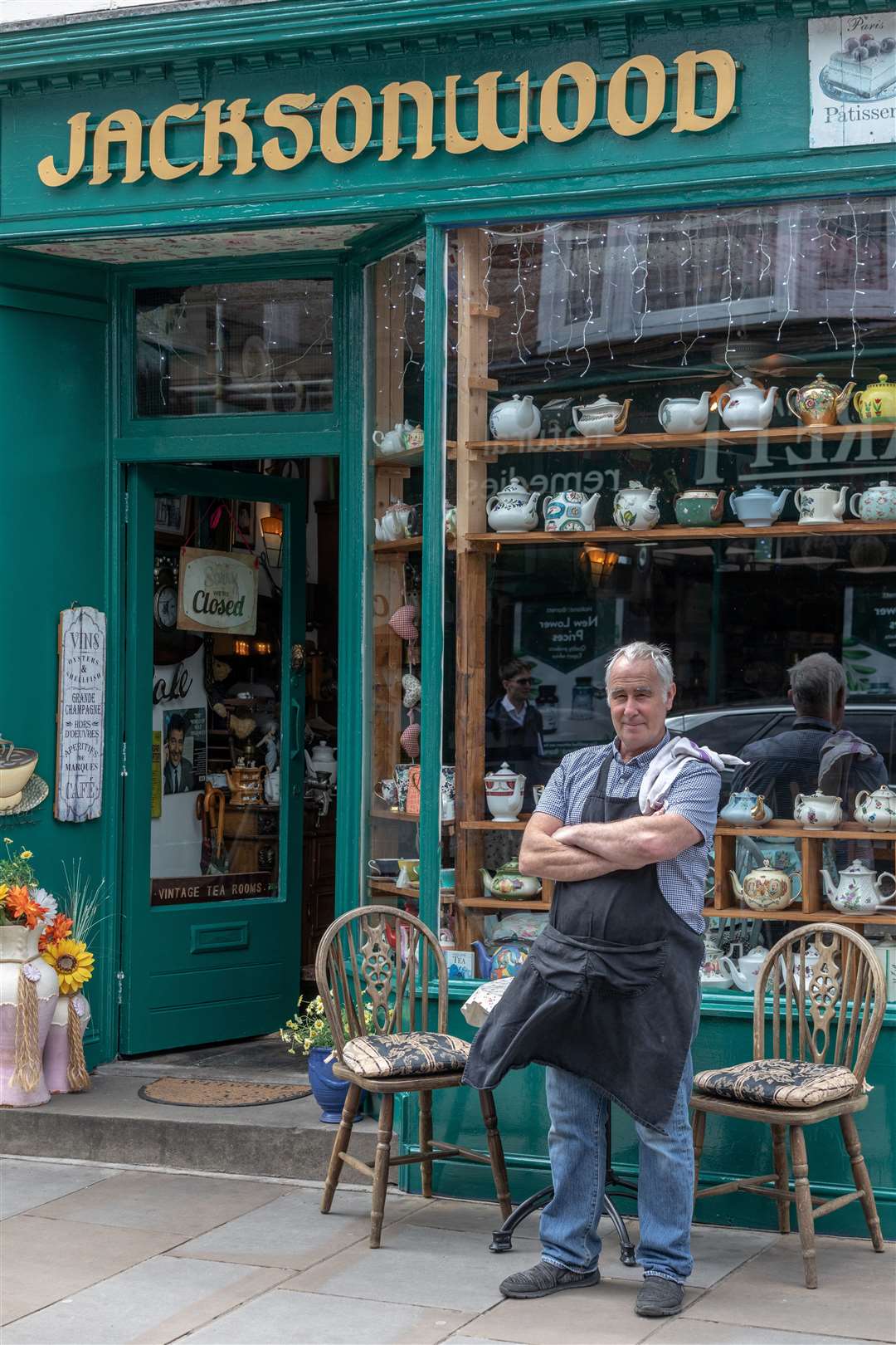 Steve Jackson outside Jacksonwood tea rooms, repainted green to match the new colours of the town's clock tower, in Sheerness High Street. Picture: SWNS/Gwyn Wright