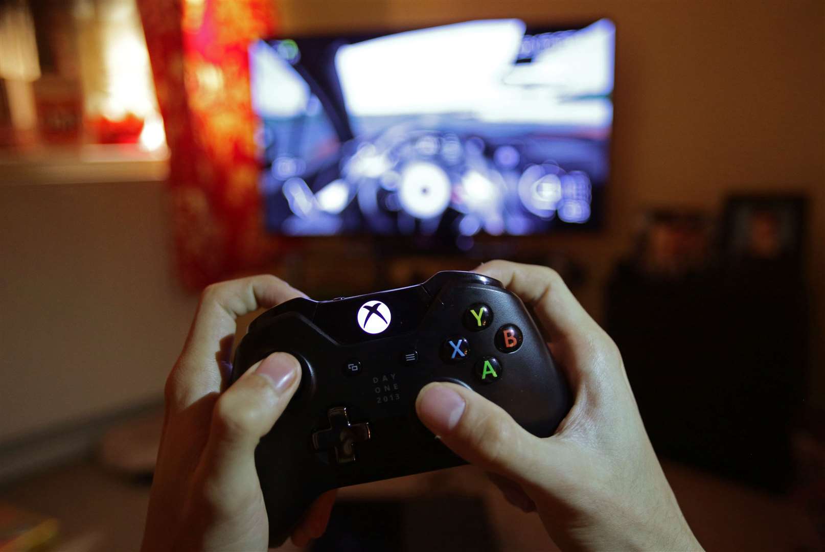 A teenager holding a controller to play the video game Forza Motorsport 5 on a Microsoft Xbox One (PA)