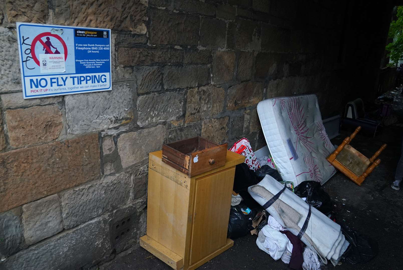 Rubbish is left beside a no fly tipping sign in Glasgow (Andrew Milligan/PA)