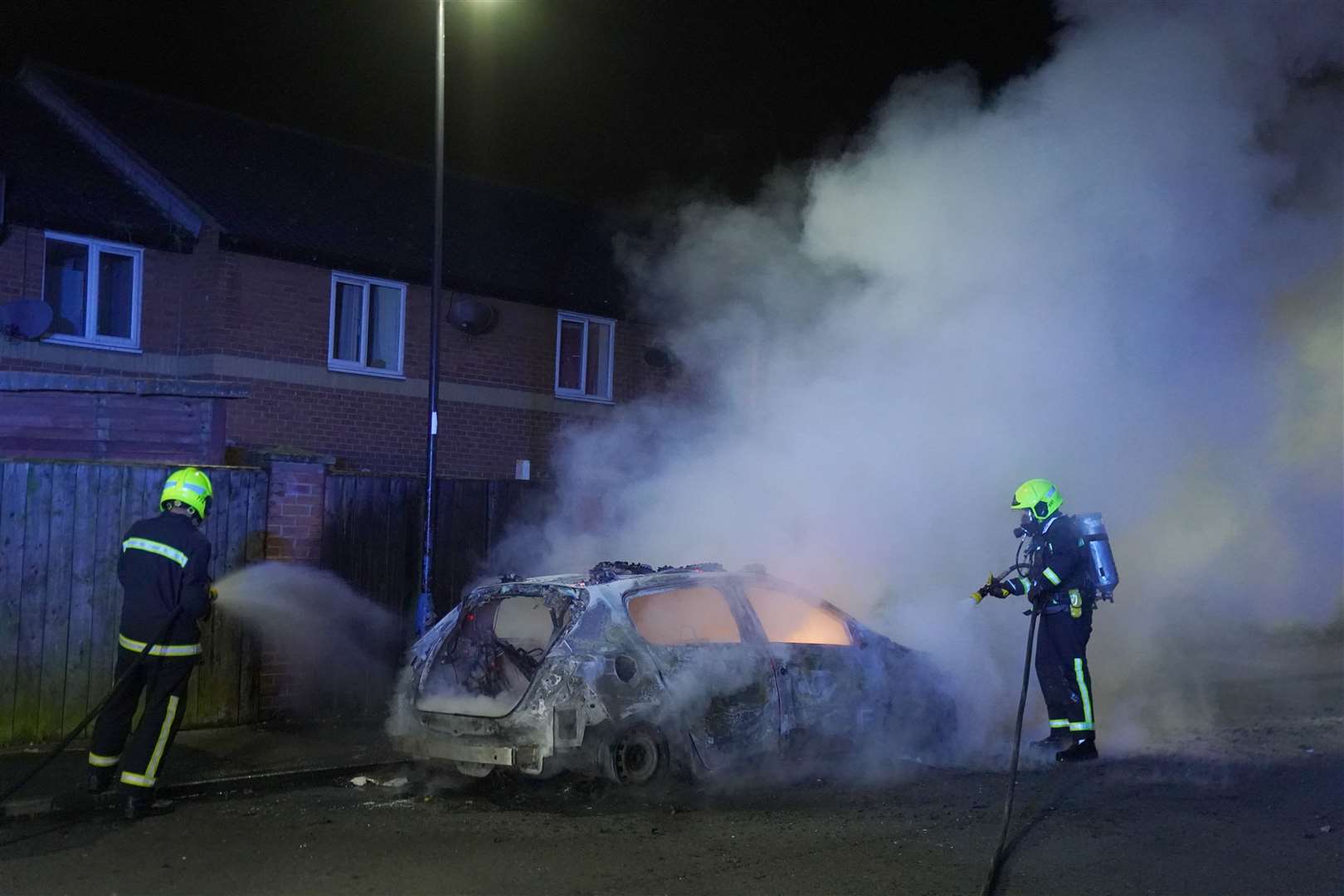 Firefighters attend a burning police car after officers were deployed on the streets of Hartlepool in July (Owen Humphreys/PA) 