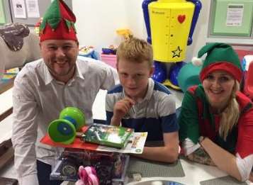 kmfm breakfast presenters Garry and Emma give a gift to a youngster in hospital last year