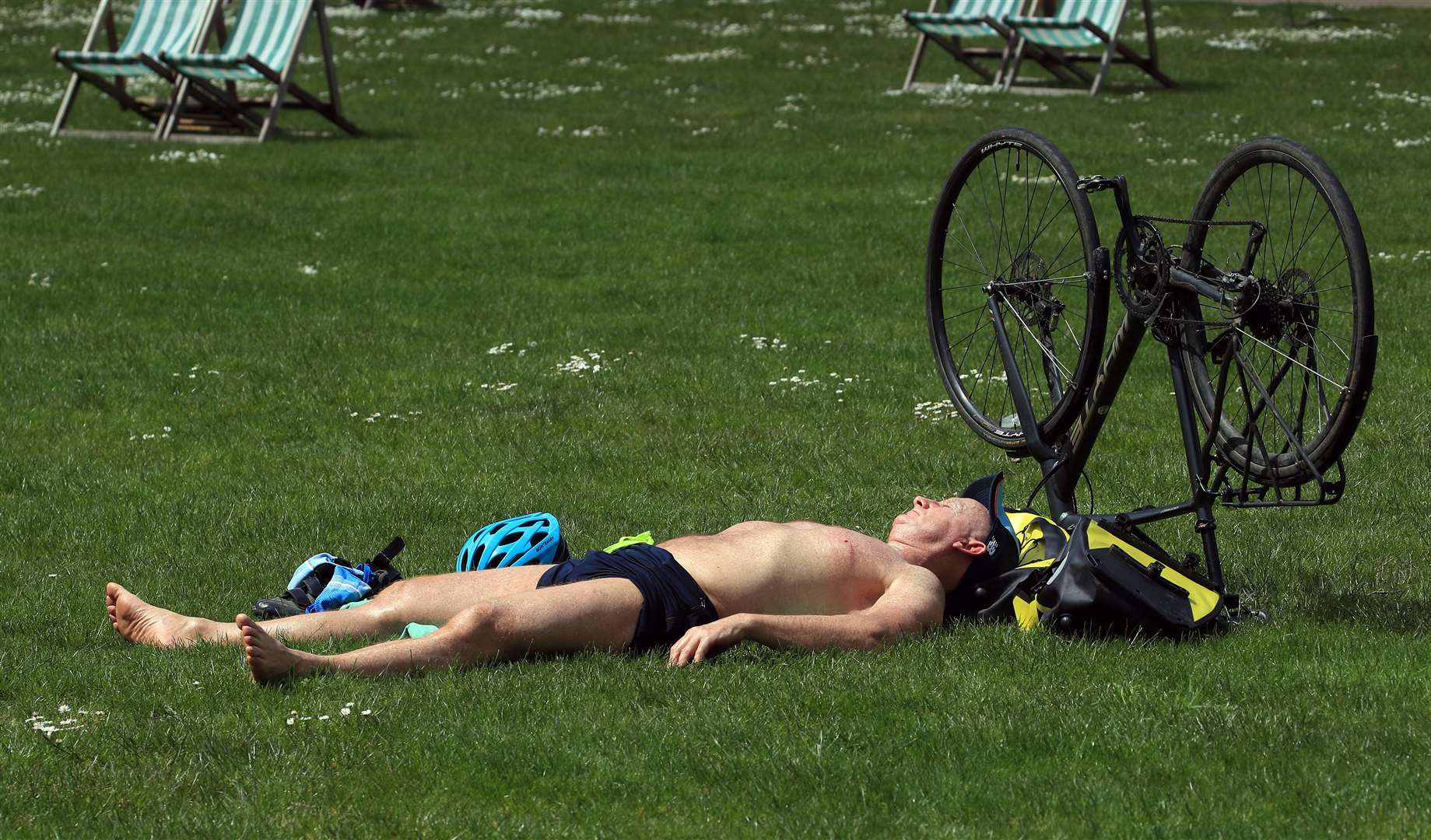 A man relaxes in the sunshine in St James’s Park in London (Gareth Fuller/PA)