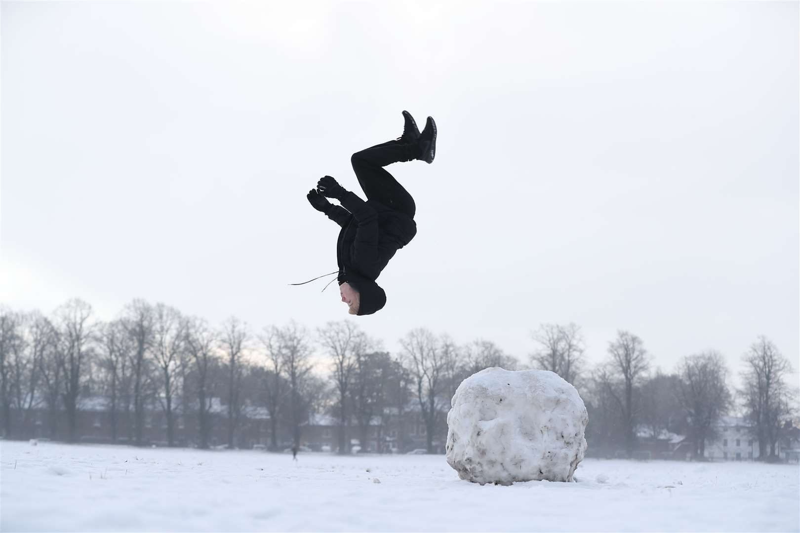 Jack Austin does a backflip off a snowball on Knutsford Heath in Cheshire (Martin Rickett/PA)