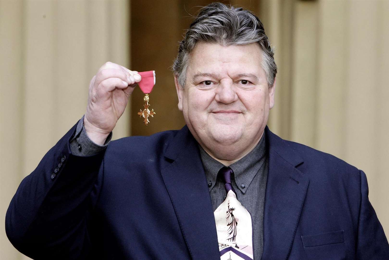 Actors Robbie Coltrane with his OBE after receiving it from the Queen at Buckingham Palace in 2006 (Andrew Parsons/PA)