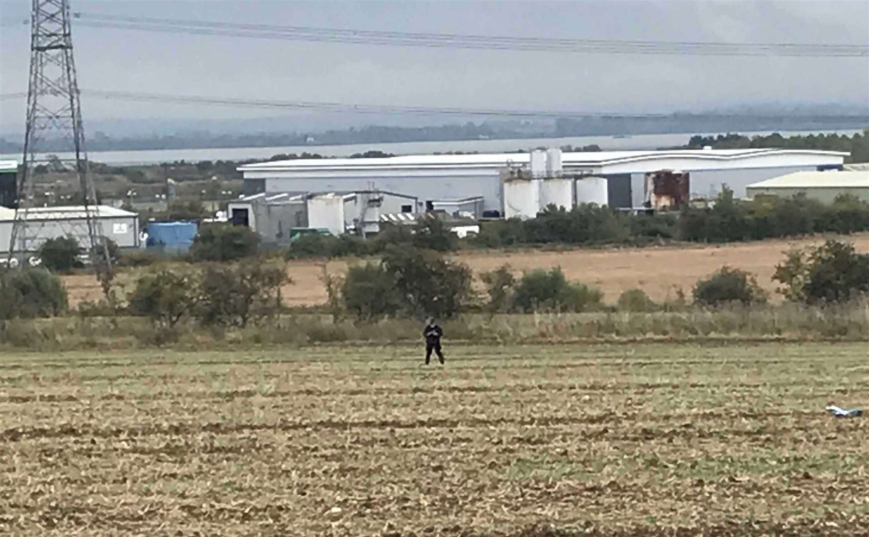 A police officer in a field off Stoke Road in the renewed search for Liam Graham