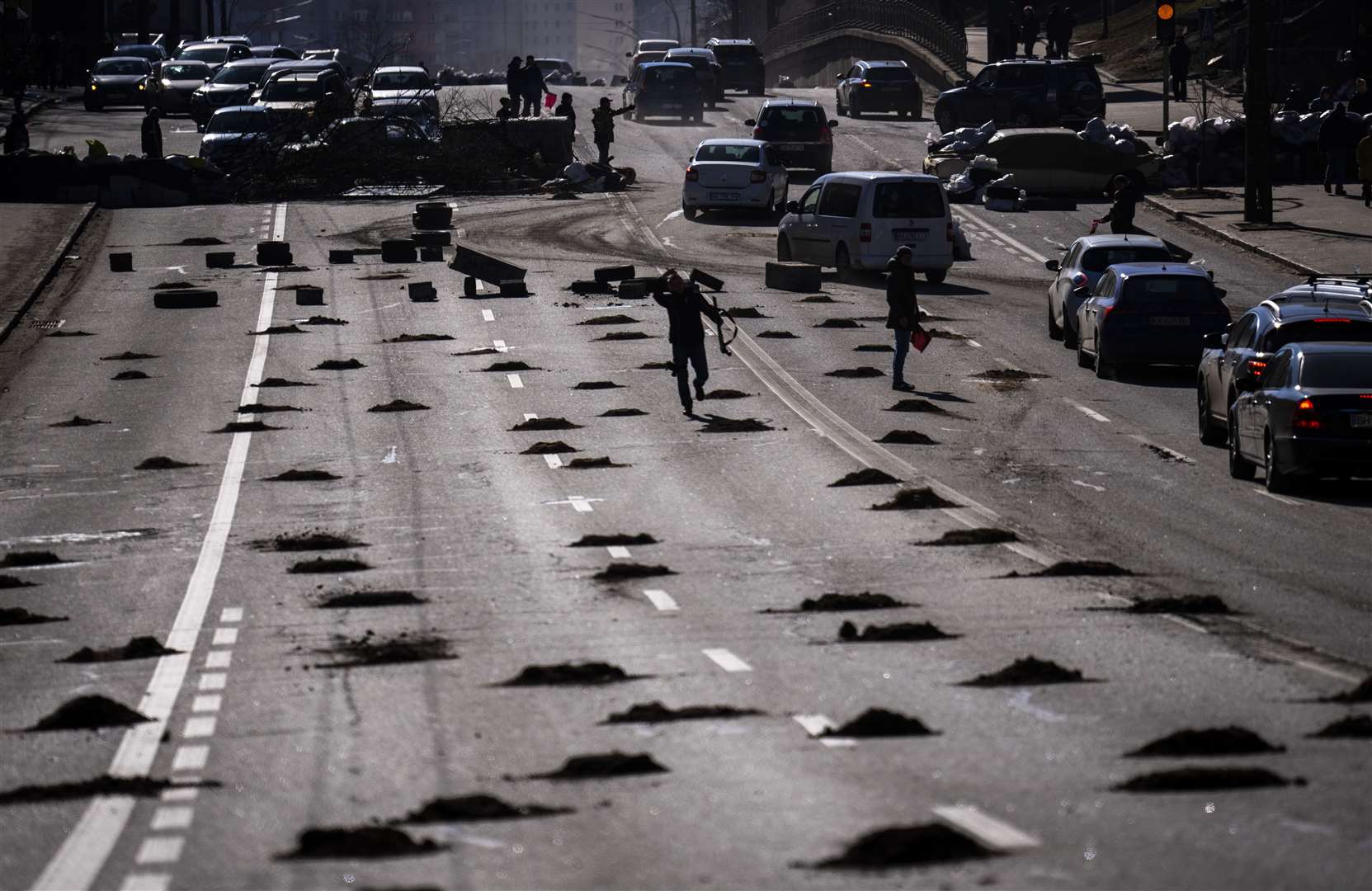 Cars are stopped at a roadblock set by civil defensemen at a road leading to central Kyiv (Emilio Morenatti/AP)