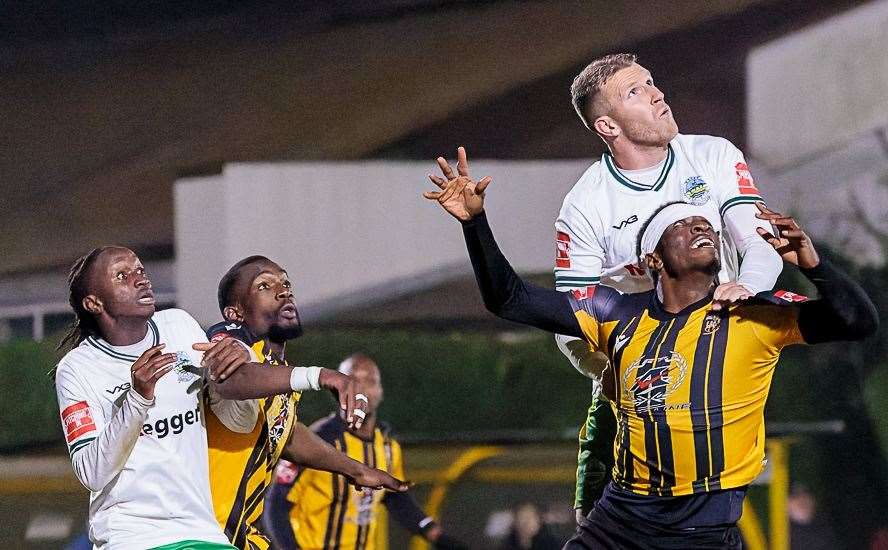 Dover defender Joe Tennent climbs above Folkestone's Marvel Ekpiteta as Whites earned a 1-0 Isthmian Premier derby victory at Cheriton Road on Tuesday. Picture: Helen Cooper