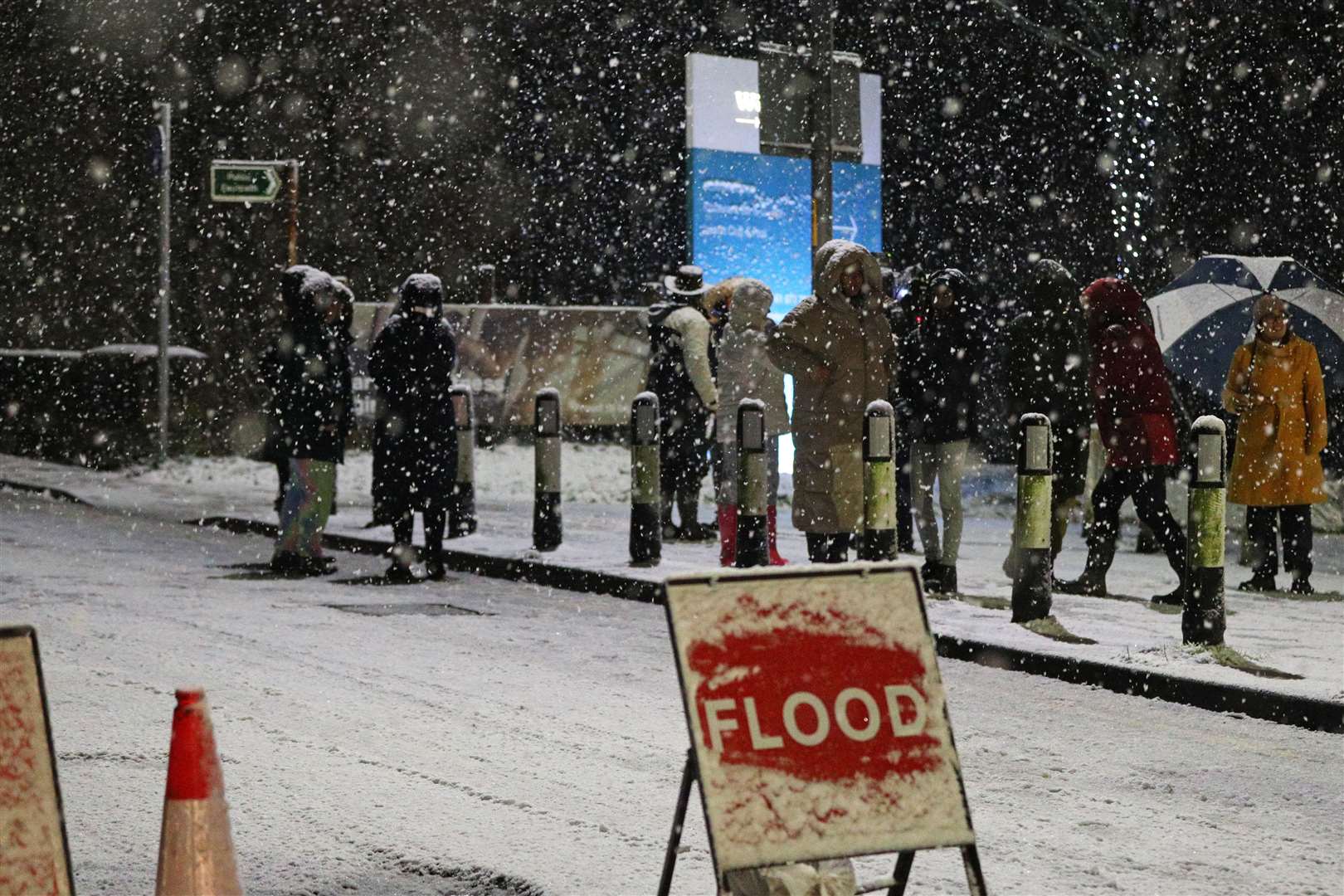 People cross a bridge over the River Mersey as snow falls in East Didsbury, Manchester (Peter Byrne/PA)