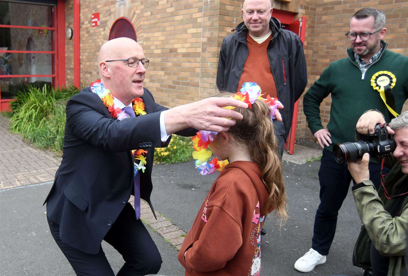 Mr Swinney presented a lei (a garland or necklace of flowers given in Hawaii as a token of welcome or farewell) to one of the children during the visit to the Jeely Piece Club in Glasgow (Michael Boyd/PA)