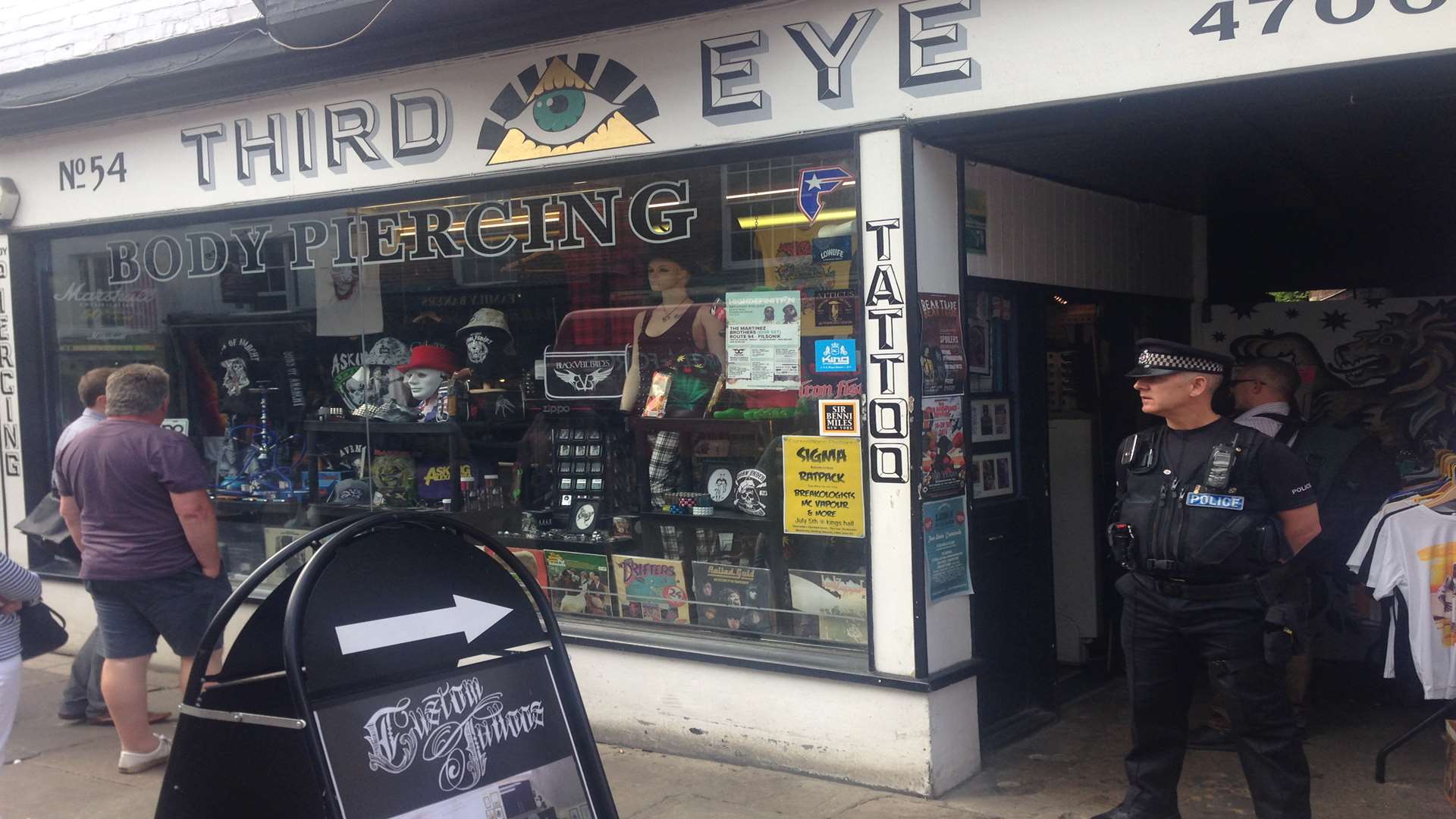 Policeman standing guard outside Third Eye in Canterbury during a raid