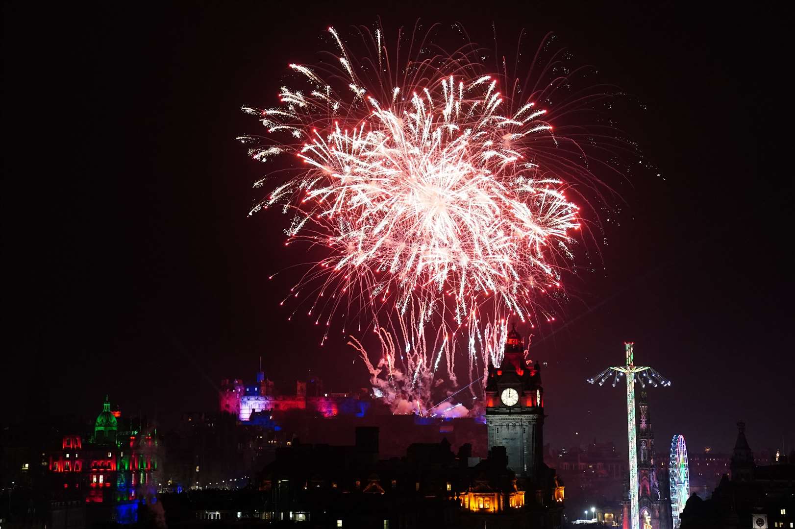 Fireworks explode over Edinburgh Castle and the Balmoral Clock as 2024 is ushered in with the Hogmanay street party (Jane Barlow/PA)