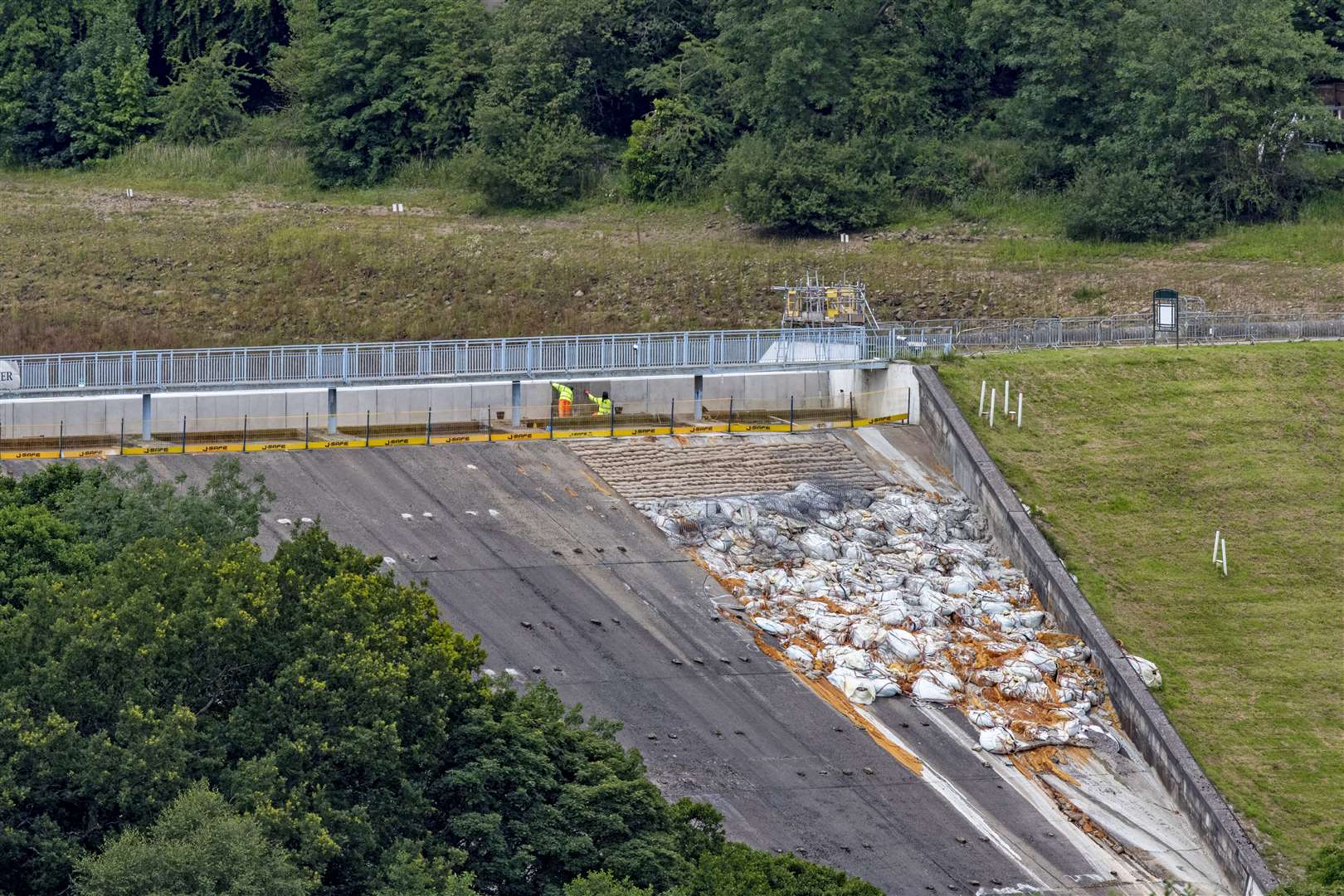 Toddbrook Reservoir, with the original sandbags still in place, is still undergoing repairs nearly a year later (Peter Byrne/PA