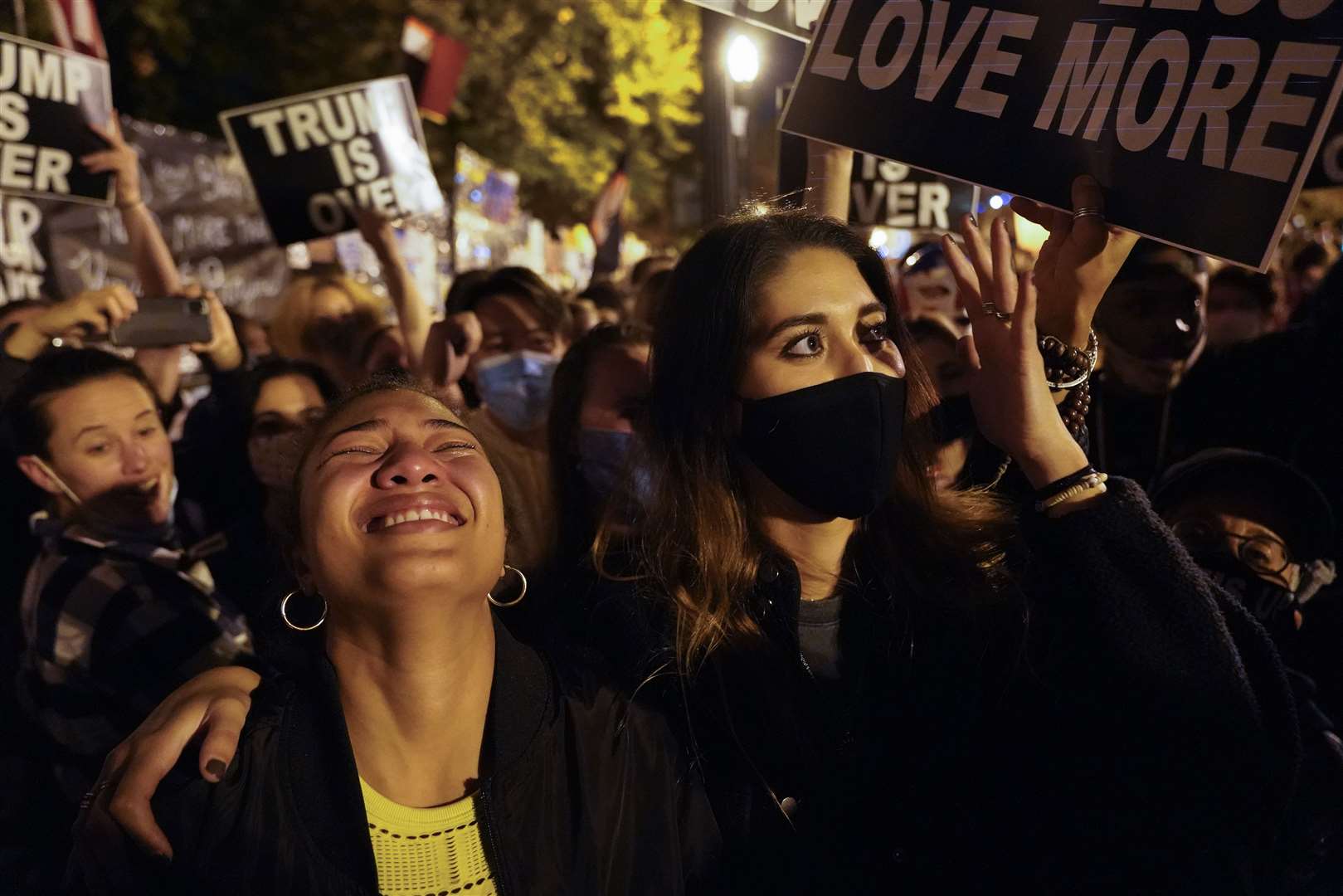 Angelique McKenna, left, and Vivian Mora, react to a speech by President-elect Joe Biden (Jacquelyn Martin/AP)