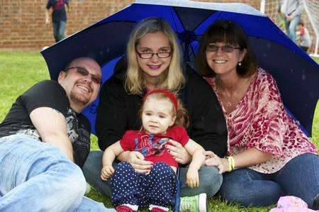 From left, as the rain falls, Steve, Rebecca and Tracey Claringbold, with Tilly Burridge, 1.